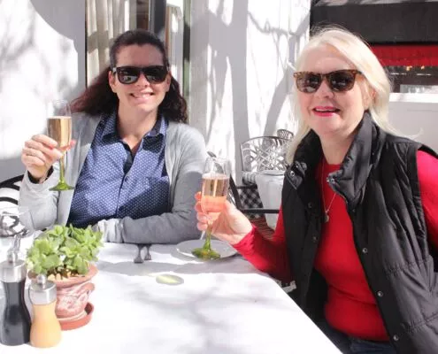 Two guests toasting on the porch